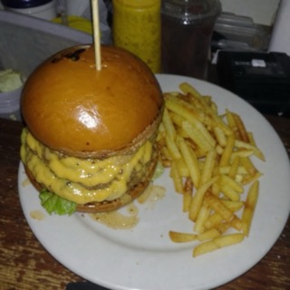 A burger photographed on a phone in dim kitchen light, before re-shooting.