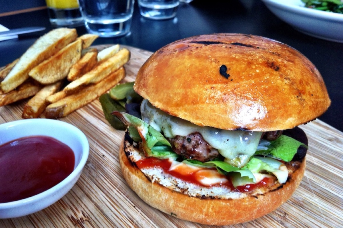 Before: the burger with glasses and bowls behind it